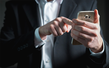 A man in a suit using a smart phone